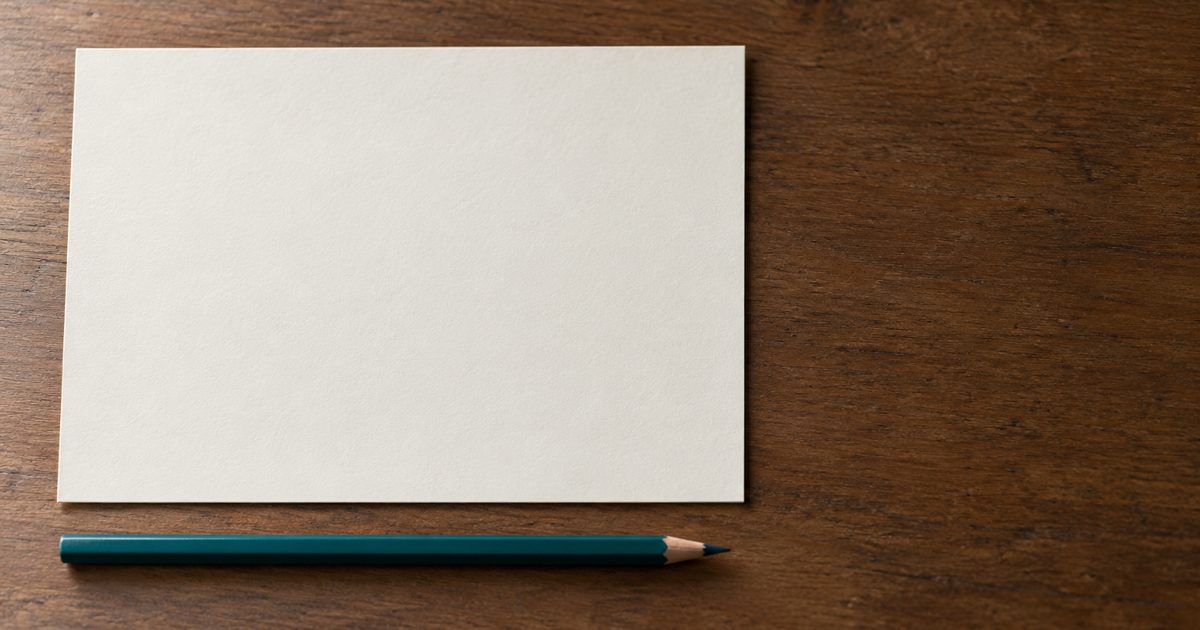 Leeres cremefarbenes Blatt mit einem parallel liegenden gespitzten Bleistift